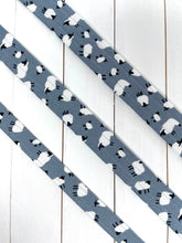 Load image into Gallery viewer, A visual comparison of sizes of a light grey dog lead with white and black sheep print on. Silver clip and Lunapalooza logo on the bottom. Available in small, medium and large.