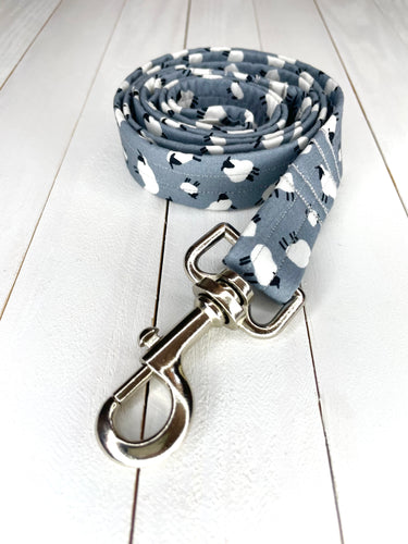 A light grey dog lead with white and black sheep print on. Silver clip and Lunapalooza logo on the bottom. Available in small, medium and large. 