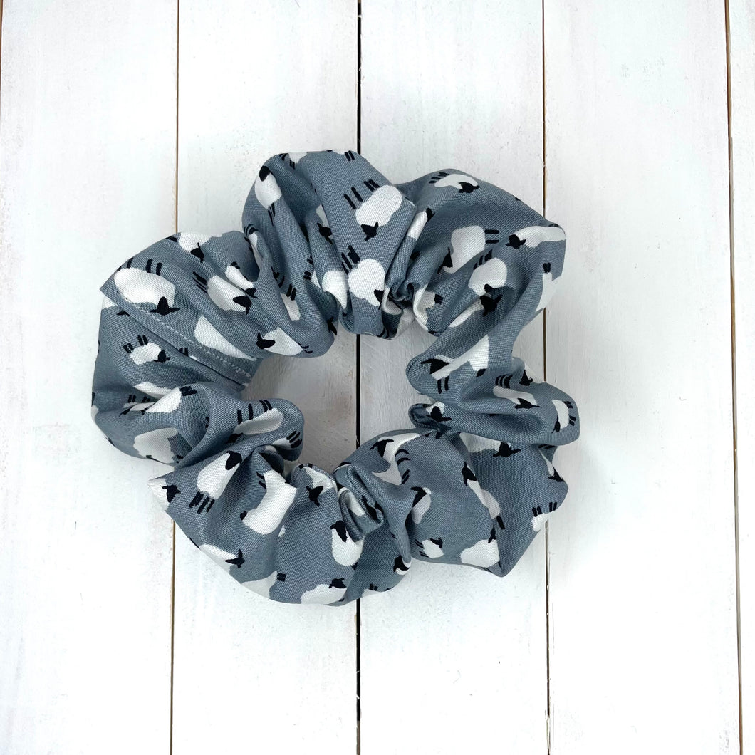 A light grey hair scrunchie with white and black sheep print on.